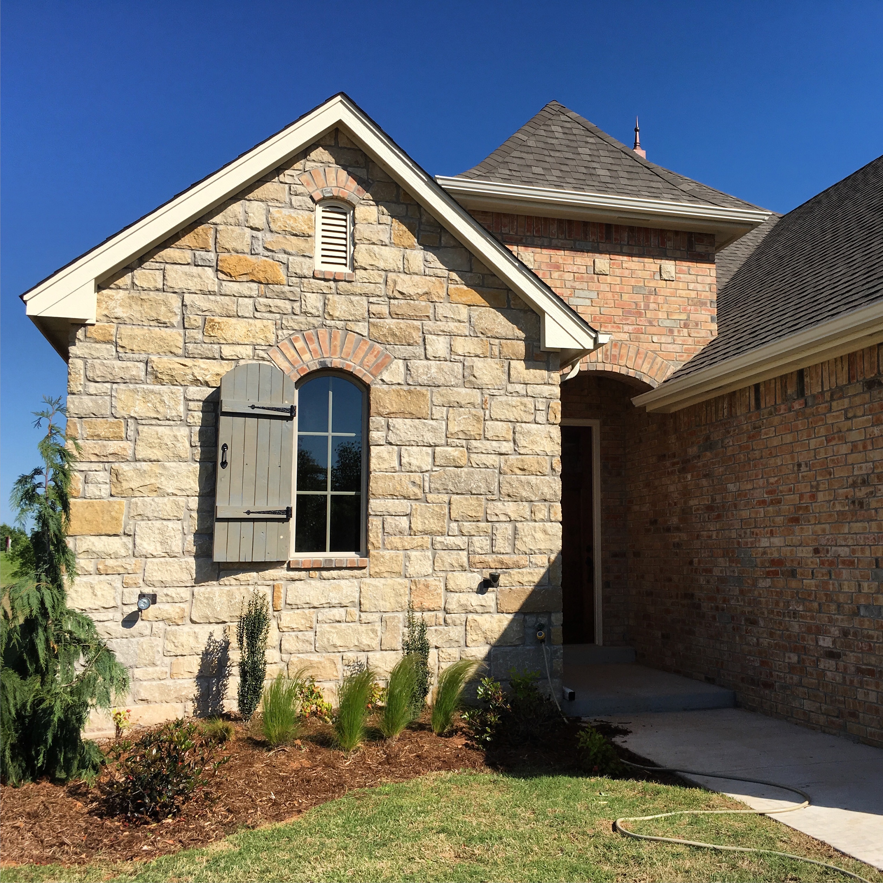 Stone detail and arched window on custom home