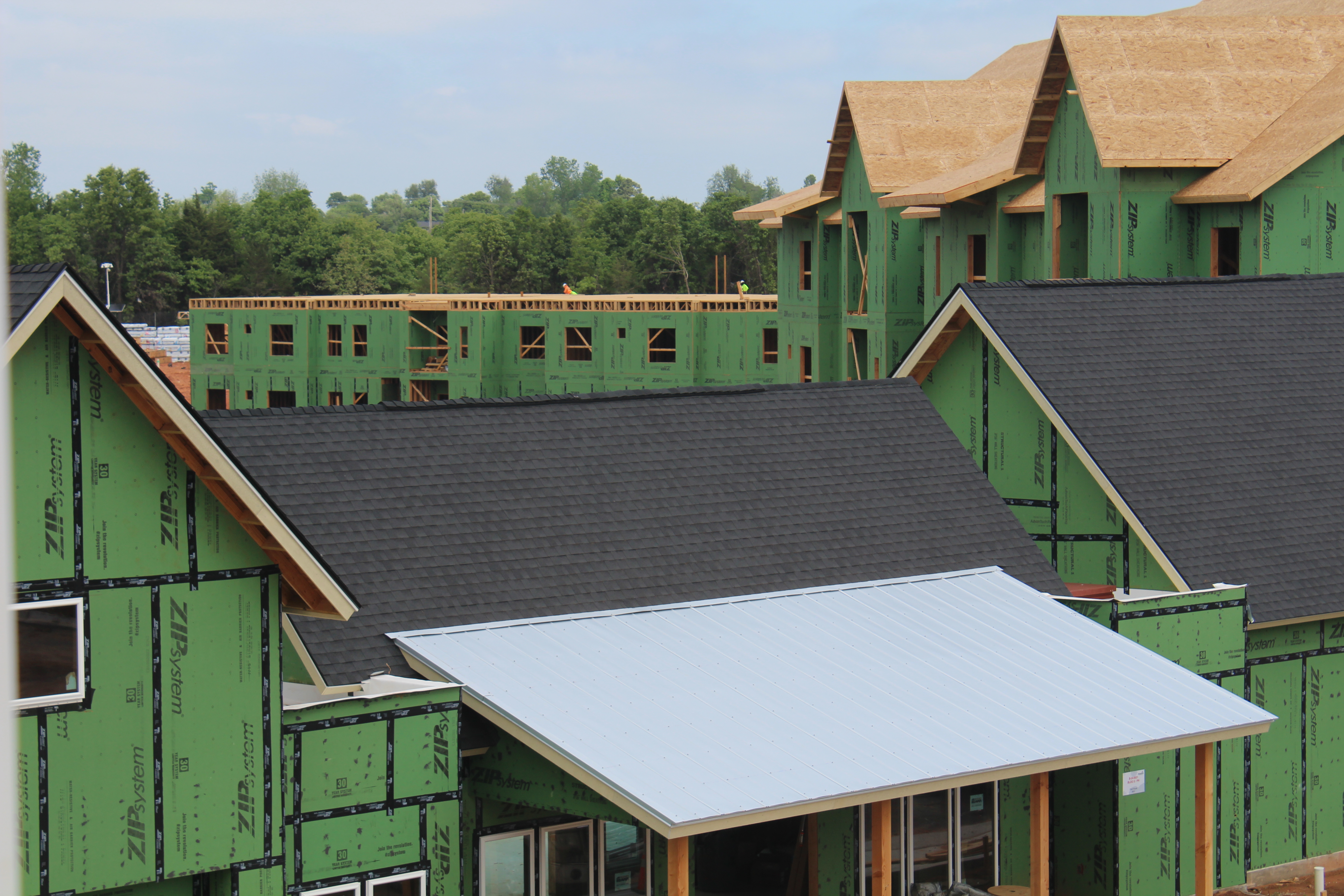 Aerial view showing shingle and metal roof systems on large complex